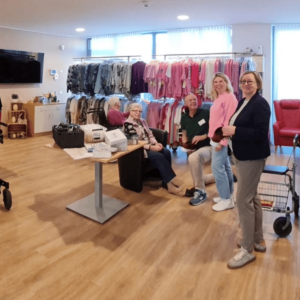 Bewohner und Mitarbeitende im Veronika-Haus beim Besuch des Modemobils mit Frühlings- und Sommermode in gemütlicher Atmosphäre