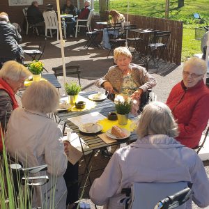 Frauen sitzen am Tisch mit Kaffee & Kuchen