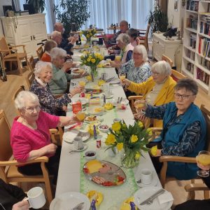 Senioren sitzen gemeinsam beim Frühstück