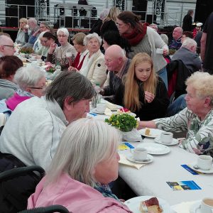 Senioren sitzen gemeinsam am Tisch im Festzelt der Kirmes