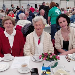 drei Frauen bei Kaffee und Kuchen im Festzelt am Tisch