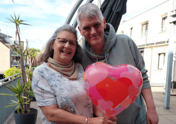 Zwei Mitarbeitende im Regina Pacis Haus Kevelaer halten einen Herzluftballon im Aufenthaltsraum zum Tag der Pflege