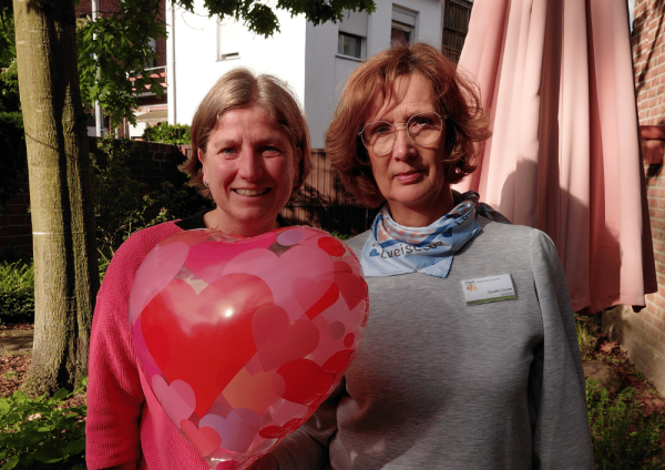 Zwei Mitarbeitende im Garten des Regina Pacis Hauses Kevelaer mit Herzluftballon zum Tag der Pflege