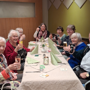 Kleine Gruppe beim Abendessen und Anstoßen im Restaurant.