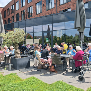 Seniorengruppe auf der Terrasse eines Cafés beim gemeinsamen Essen.