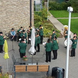 Eine Blaskapelle in grünen Uniformen spielt im Innenhof, aufgenommen aus erhöhter Perspektive.