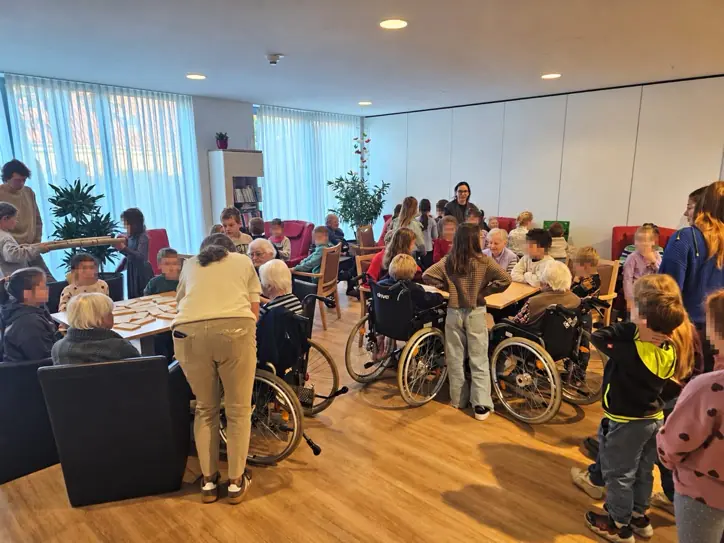 Kinder und ältere Menschen sitzen an mehreren Tischen und spielen gemeinsam Gesellschaftsspiele im Seniorenheim.