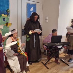 Bewohnerinnen und Ordensschwestern führen in Kostümen ein Theaterstück auf, begleitet von Musik am Keyboard.
